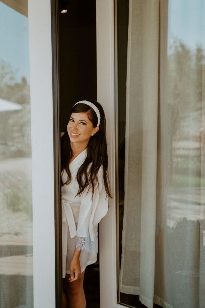 Bride popping out of a beautiful glass door — Desert Wedding Photography by Mattie O'Neill