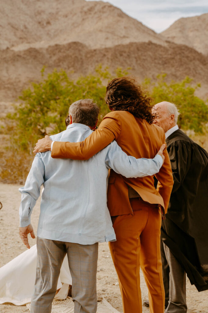 Groom and father of the bride hugging — Desert Wedding Photography by Mattie O'Neill