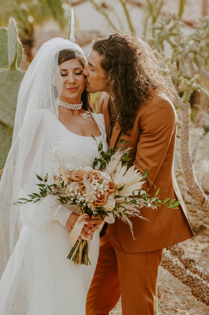 Groom kissing bride on cheek  — Desert Wedding Photography by Mattie O'Neill